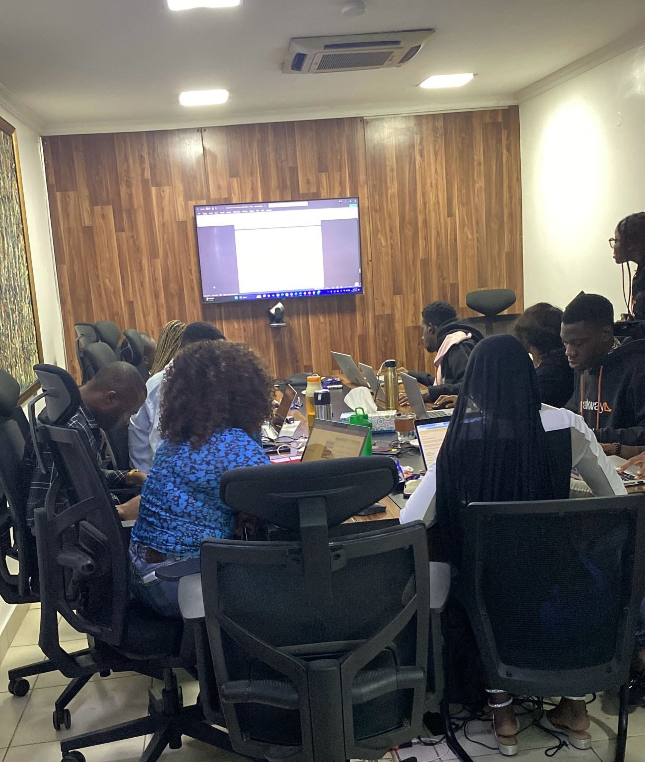 Support team participants working on laptops during the training workshop